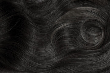 Brunette or black hair. Female long dark hair in black. Beautifully laid curls. Closeup texture in...