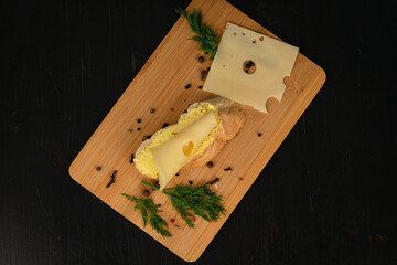 Sandwich with butter and cheese on a wooden board