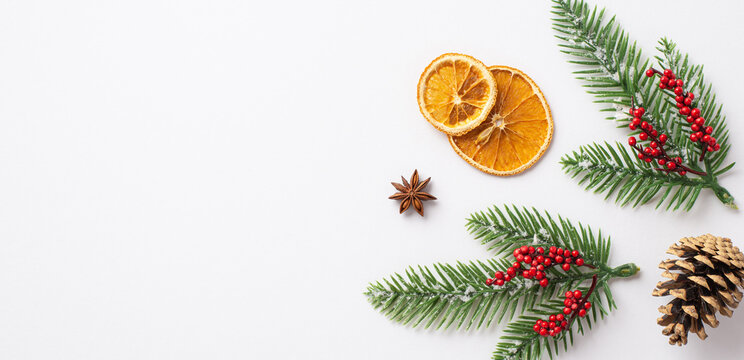 Christmas Concept. Top View Photo Of Fir Branches In Snow Mistletoe Berries Pine Cone Anise And Dried Orange Slices On Isolated White Background With Empty Space