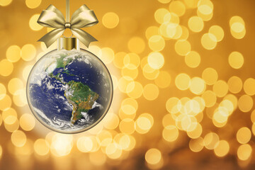 Christmas peace on earth goodwill to all concept showing glowing Xmas bauble with planet earth inside on golden bokeh background and copy space. Elements of this image furnished by NASA.