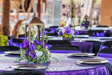Wedding reception table, formal event tale centerpiece, sweet sixteen party, quinceanera decorations, black tablecloth, purple flowers, lantern,