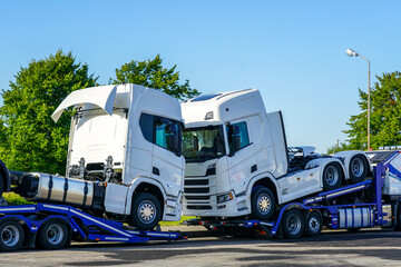 Transporting brand new trucks on specialized truck trailers, delivery to dealers