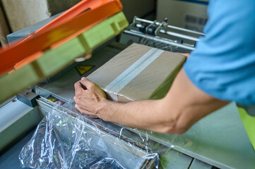 Storehouse operator hands packing goods for delivery