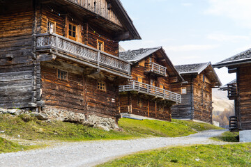 Fototapeta na wymiar Idyllic group of historic wooden farm houses on a alpine pasture in Austria during autumn