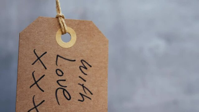 With love handwritten message for gift on gray background 