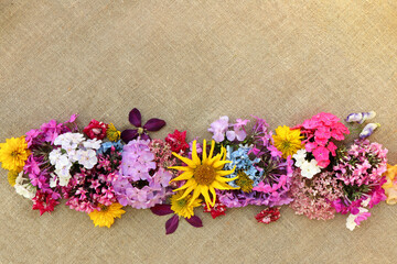 Floral design composition of a variety of flowers on burlap.