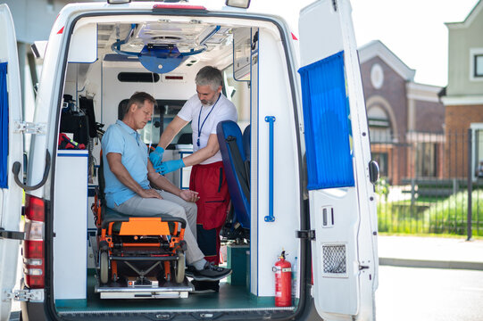 Experienced Paramedic Preparing A Patient For The IV Drip