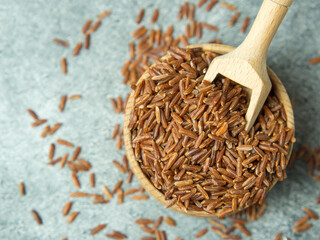 brown rice closeup in a wooden bowl and scoop