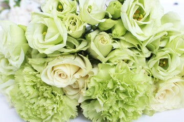 Solid background of white roses, light salad carnations and eustoma. Delicate floral arrangement. Background for a greeting card.
