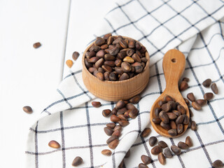pine nuts in shell on white wooden background