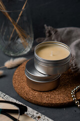 Soy candles in metal cans, handmade modern hobby , soy wax candles on cozy background.Massage candles.