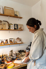 art workshop, messy objects, brushes, paint all mixed up disorganized, woman artist