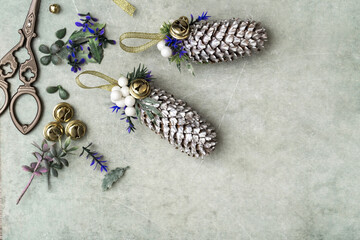 Vintage Christmas decorations. Cones painted with silver acrylic paints, bells and ribbons, artificial spruce and berries. Copy Space - 544437711
