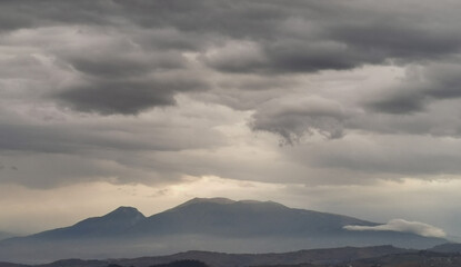 Monti Appennini avvolti di nebbie e nuvole e chiarori di sole
