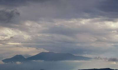 Fototapeta na wymiar Monti Appennini avvolti di nebbie e nuvole e chiarori di sole