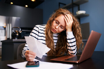 Unhappy woman calculates expenses on bills, upset about increased utilities prices. Female counting...