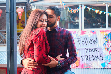 A beautiful Indian married couple is walking in a European city. A stylish place in the Urban style. Love and joyful relationships.