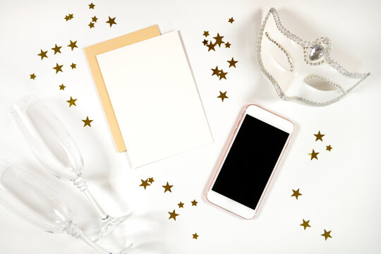 New Year's Eve 5x7 greeting card, party invitation and cellphone, mobile phone eVite eCard mockup with white mask and champagne glasses. Styled stock minimalist mock up.