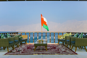 Oman Flag on a boat with sea and mountain backgrounds 