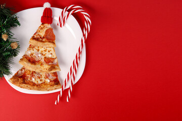 New Year. Christmas. pizza.new year's pizza. pizza chunks are in the shape of a Christmas tree. New Year's composition on a plate.