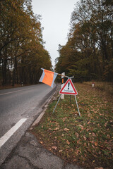 on the side of the road there is a sign with a flag with the warning Treibjagd