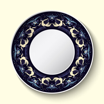 Top view of dark blue ceramic plate with painted birds and flowers ornament on the edge. Tableware dish isolated on light background. Stylized classic cobalt painting on porcelain