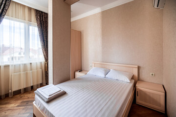 Fototapeta na wymiar Apartments for rent. large bright double bed in the bedroom.white pillows at the headboard