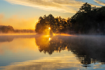 Sunrise over a foggy lake in autumn