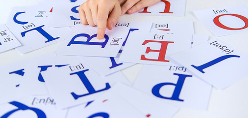The child learns English letters. Selective focus. - obrazy, fototapety, plakaty
