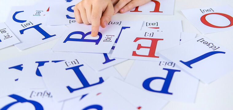 The child learns English letters. Selective focus.