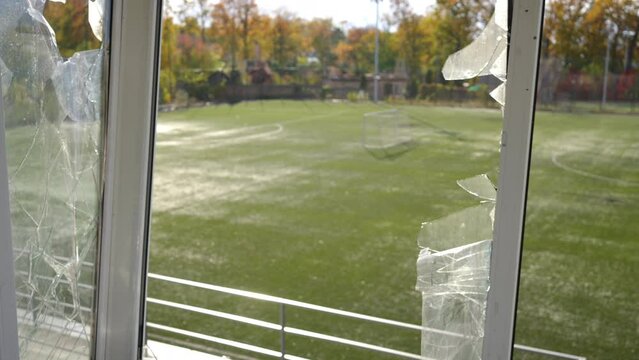 Broken Glass Of Ruined Commentator Booth On Autumn Sports Field In Kiev Ukraine. Shooting From Inside Of Empty Stadium In War Zone In Sunshine. Slow Motion