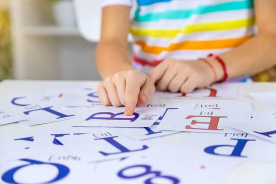 The child learns English letters. Selective focus.