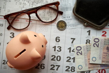 paragony fiskalne ,polskie banknoty , polska moneta, kartka z kalendarza, świnka skarbonka, emerytura	