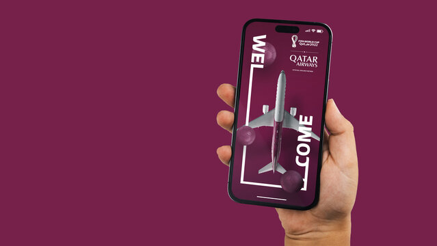 Boy holding a smartphone iPhone 14 Pro with Qatar Airways app on the screen. Wine background. Rio de Janeiro, RJ, Brazil. November 2022