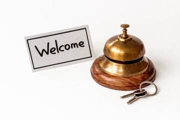 Hotel service bell on reception desk with welcome word on paper