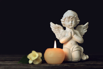 Angel, white flowers and burning candle