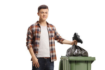 Smiling young man throwing a waste bag in a bin
