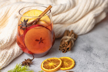 A glass of hot mulled wine with pieces of orange and apples with cinnamon and anise. Traditional...