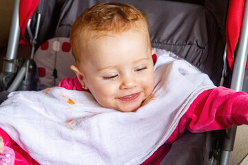 Feeding her cute baby son from spoon at home, giving healthy food to her little daughter