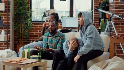 Disappointed football fans losing game match on television, watching soccer championship...