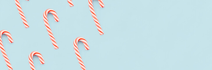 Christmas composition. Banner made of red and white candies on blue background. Christmas, winter, new year concept. Minimal style. Flat lay, top view, copy space.