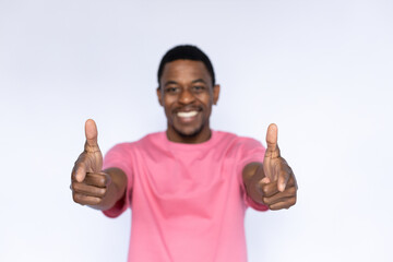 Portrait of joyful African American man pointing at camera. Happy young male model with short dark hair in pink T-shirt looking at camera, laughing and choosing you. Choice, advertisement concept