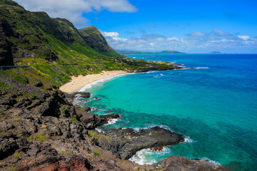 Fototapeta na wymiar Green mountains over Makapu'u Beach Park with the translucent waters of the Pacific Ocean on the eastern side of Oahu island in Hawaii, United States