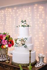 a 4-tier wedding cake, and flower arrangements on a table
