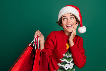 Photo of astonished funny person hand touch cheek hold packages look empty space isolated on green color background