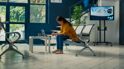 Medical assistant asking patient to start checkup examination at healthcare clinic, sitting in waiting area. Nurse taking asian woman to attend appointment and give support and advice.