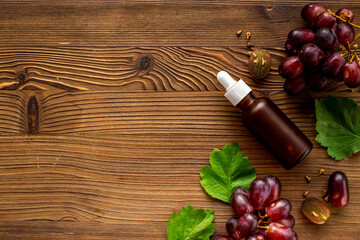 Grape seed essential oil with bunch of grapes. Eco cosmetic product
