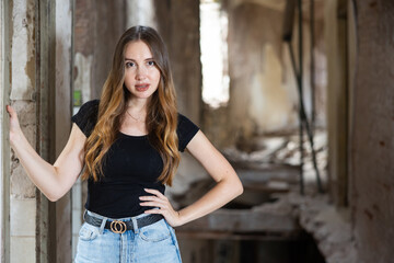 Portrait of attractive young caucasian woman posing in abandoned building.