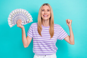 Closeup photo of beautiful lady hands fists up hold bucks money look glad hooray screaming celebrate win lottery isolated on cyan color background