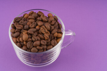 Coffee beans in a transparent cup. Closeup. Place for text